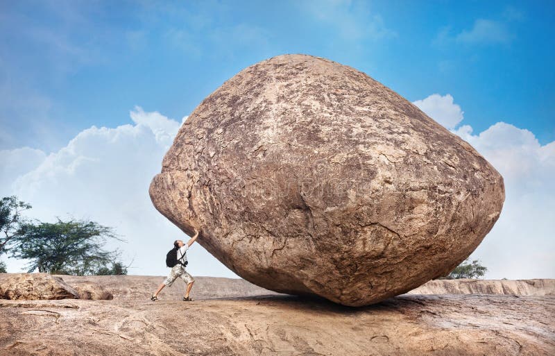 Homme poussant une grande pierre