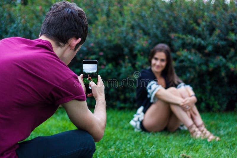 Homme prenant la photo des femmes avec le téléphone intelligent image libre de droits Homme prenant la photo des femmes avec le téléphone intelligent image libre de droits