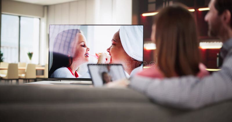 Homme regardant Internet en streaming de tablette connectée à la télévision photographie stock libre de droits
