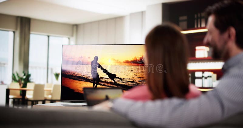 Homme regardant Internet en streaming de tablette connectée à la télévision photos libres de droits