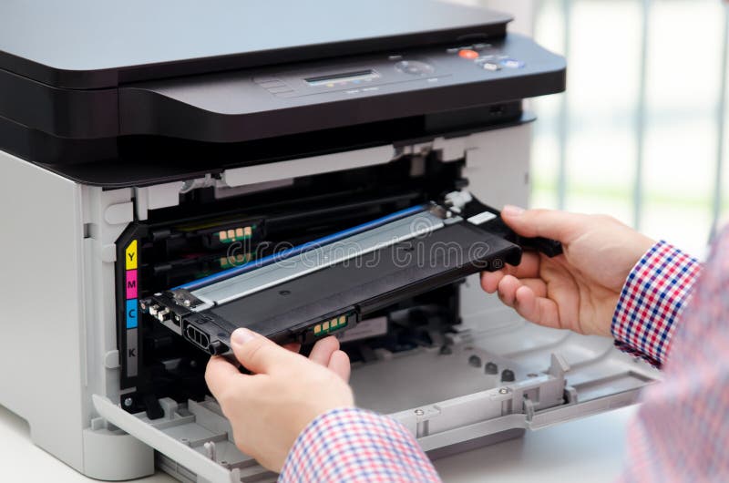 Homme remplaçant le toner dans l'imprimante à laser photographie stock libre de droits Homme remplaçant le toner dans l'imprimante à laser photographie stock libre de droits