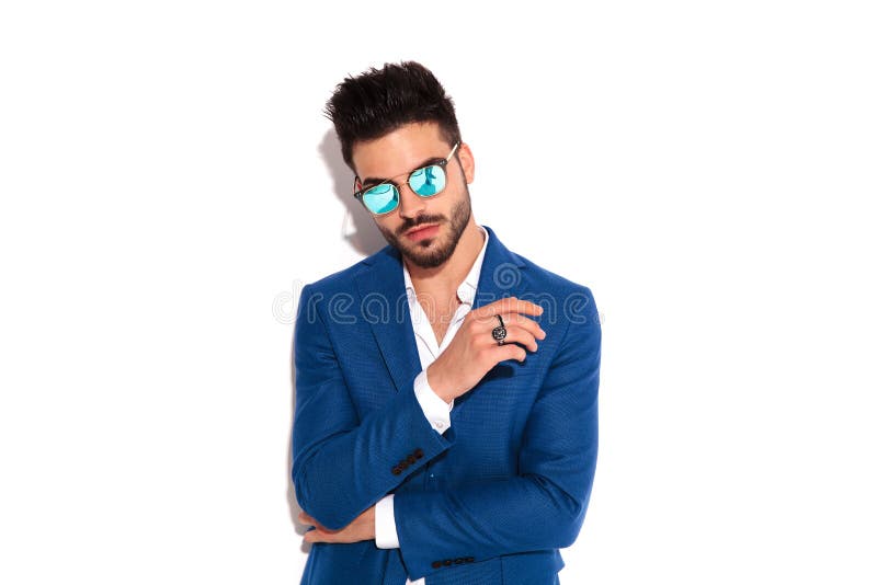 Homme sûr de mode dans les lunettes de soleil et le manteau bleu images libres de droits Homme sûr de mode dans les lunettes de soleil et le manteau bleu images libres de droits