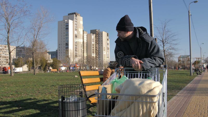 Homme sans abri mûr rassemblant le plastique des déchets