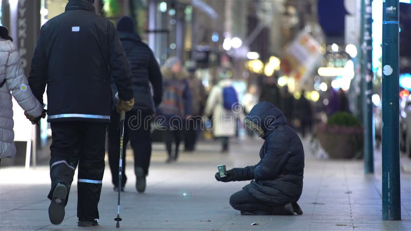 Homme sans abri non identifié priant sur la rue de la ville européenne