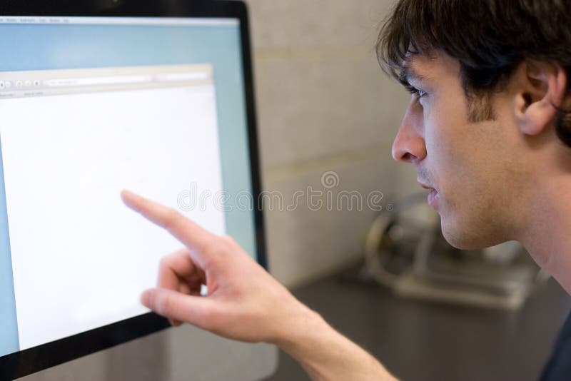 Homme se dirigeant à l'écran d'ordinateur photo libre de droits Homme se dirigeant à l'écran d'ordinateur photo libre de droits