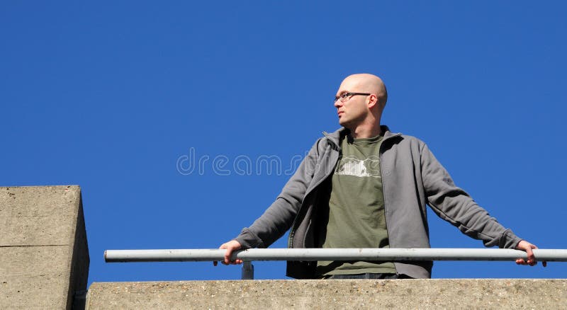 Homme se penchant sur la balustrade photo stock Homme se penchant sur la balustrade photo stock