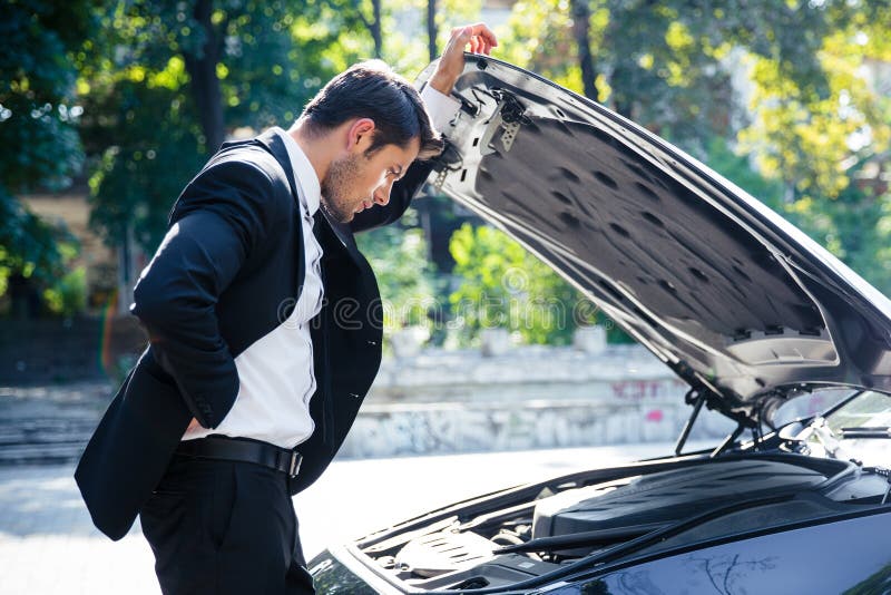 Homme se tenant près de la voiture cassée photo libre de droits Homme se tenant près de la voiture cassée photo libre de droits