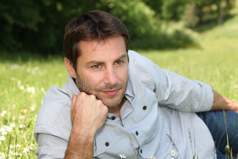 Homme se trouvant sur l'herbe image stock Homme se trouvant sur l'herbe image stock