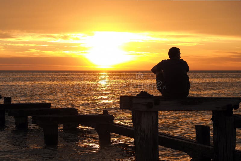 Homme seul observant le coucher du soleil au port Philip Bay photo libre de droits Homme seul observant le coucher du soleil au port Philip Bay photo libre de droits