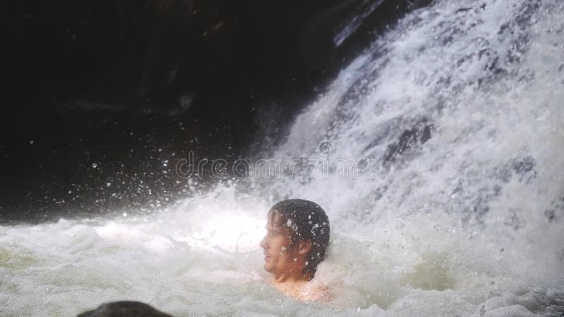 Homme sexy bel détendant sous l'eau de ruisseau en cascade dans la jungle tropicale Mouvement lent 1920x1080