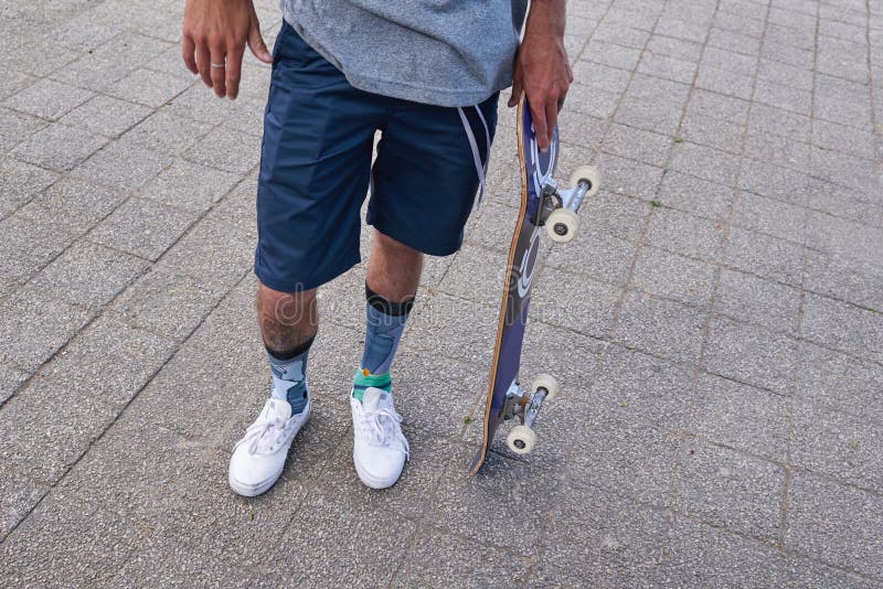 Homme skateboarder et jambes en ville rider et gars pour le défi de patinage en vacances. Fitness Hobby extérieur et images libres de droits