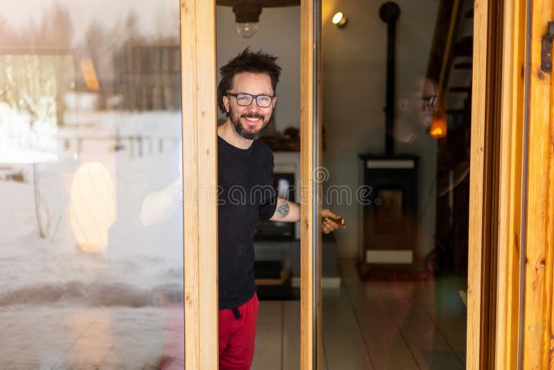 Homme souriant debout à l'entrée de la maison photo libre de droits