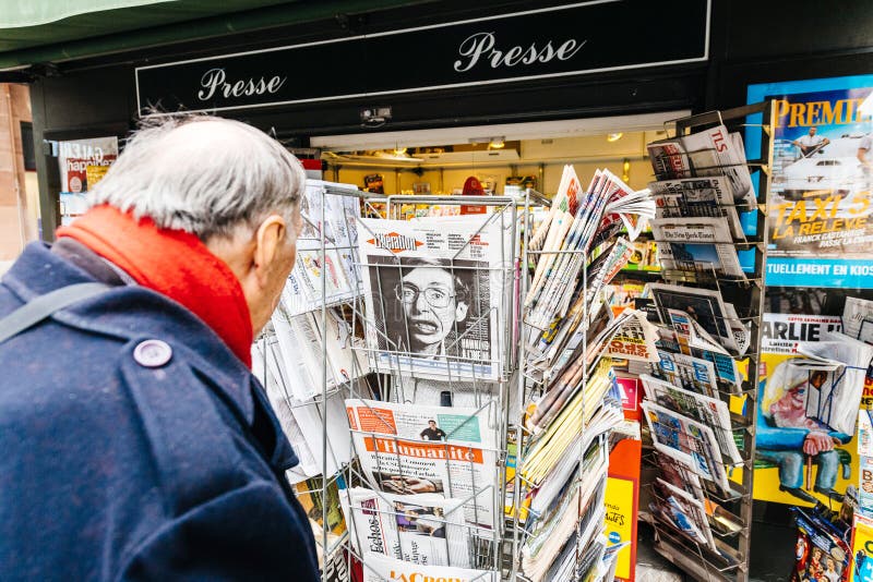 Homme supérieur achetant la libération française de journal à la presse parisienne images libres de droits Homme supérieur achetant la libération française de journal à la presse parisienne images libres de droits