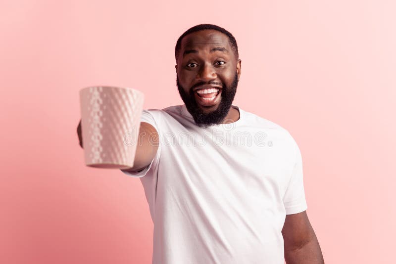 Homme sur le mur rose tenant une tasse chaude de café regard excité publicité concept photos libres de droits