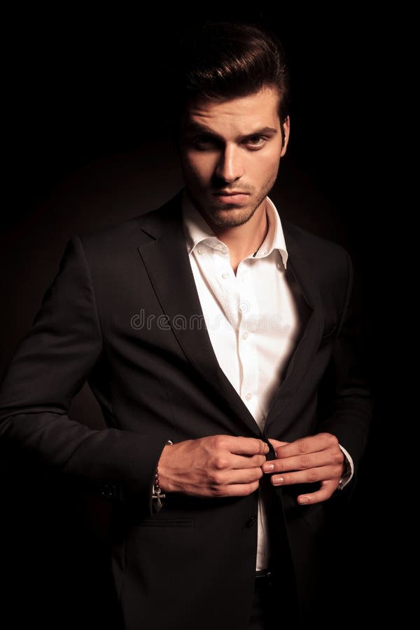 Homme sérieux d'affaires de mode ouvrant son manteau image stock Homme sérieux d'affaires de mode ouvrant son manteau image stock