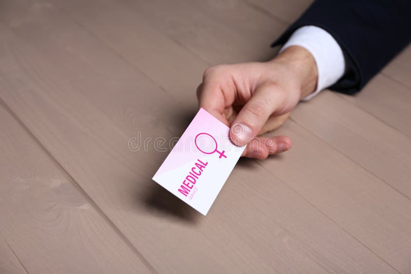 Homme tenant la carte de visite professionnelle de visite médicale à la table, plan rapproché r photographie stock Homme tenant la carte de visite professionnelle de visite médicale à la table, plan rapproché r photographie stock