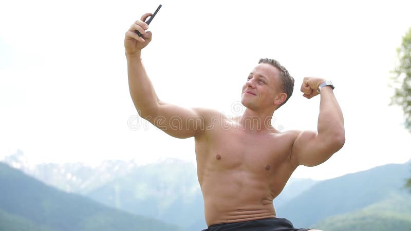 Homme tenant le téléphone intelligent et prenant un extérieur de selfie au-dessus de nature de montagnes