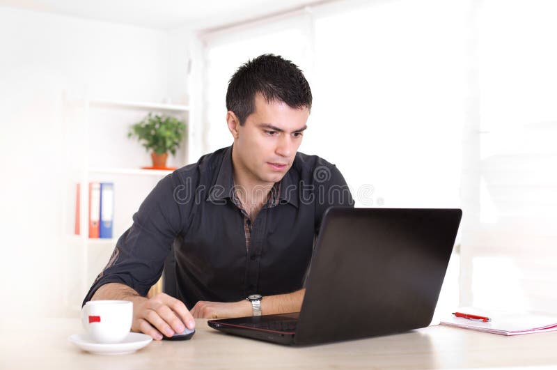 Homme travaillant sur l'ordinateur portable dans le bureau photographie stock Homme travaillant sur l'ordinateur portable dans le bureau photographie stock