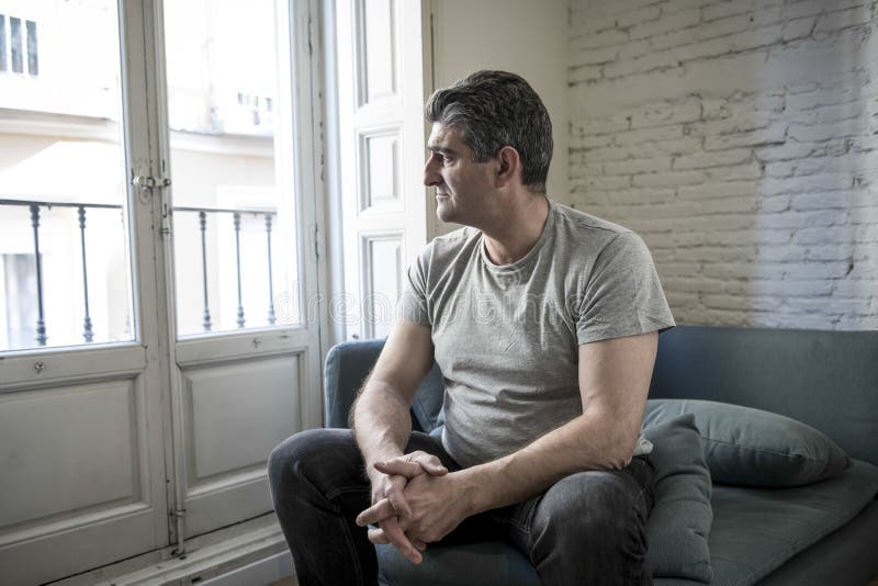 Homme triste et inquiété avec les cheveux gris reposant à la maison le regard de divan images libres de droits Homme triste et inquiété avec les cheveux gris reposant à la maison le regard de divan images libres de droits