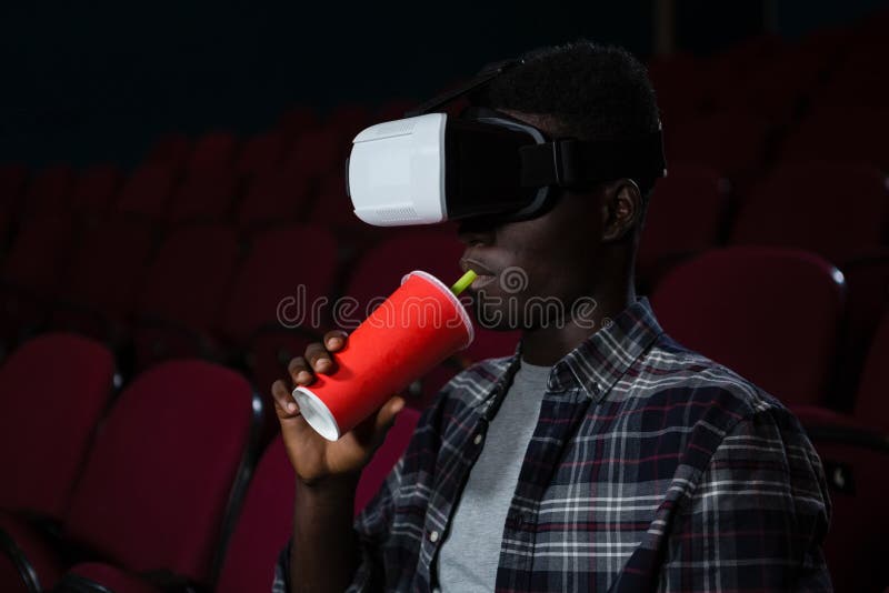 Homme à l'aide du casque de réalité virtuelle tout en observant le film images stock Homme à l'aide du casque de réalité virtuelle tout en observant le film images stock