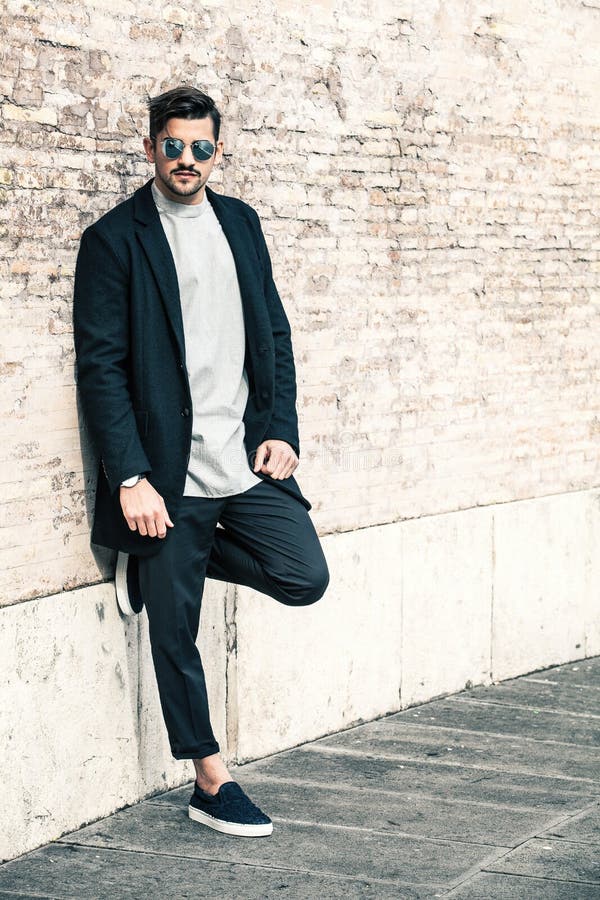 Homme à la mode bel, mur de briques blanc photographie stock libre de droits Homme à la mode bel, mur de briques blanc photographie stock libre de droits
