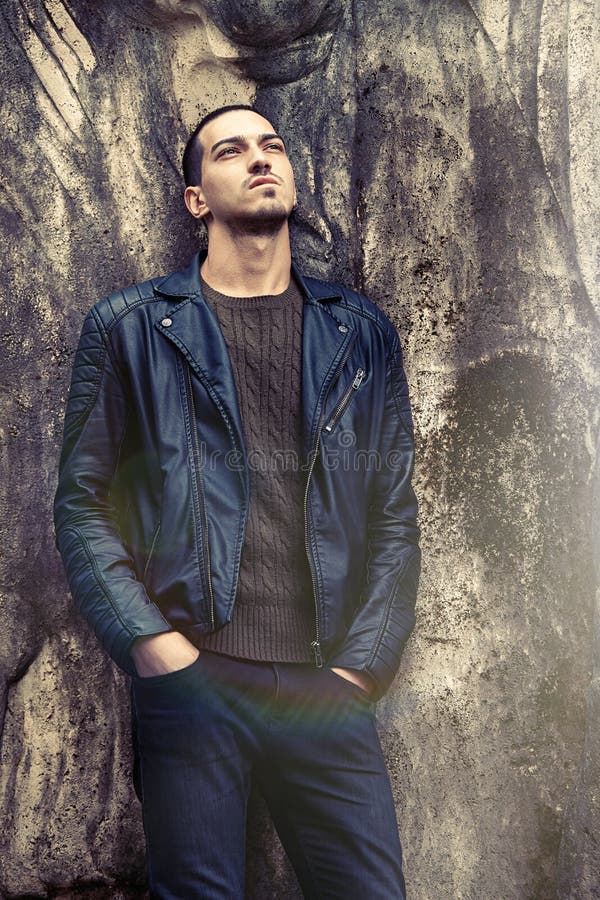 Homme à la mode frais se penchant contre le mur Habillement de style de roche photographie stock libre de droits Homme à la mode frais se penchant contre le mur Habillement de style de roche photographie stock libre de droits