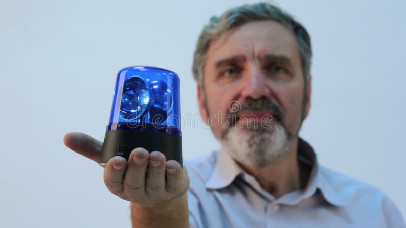 Homme âgé avec barbe tient la clignotant bleu à la main banque de vidéos