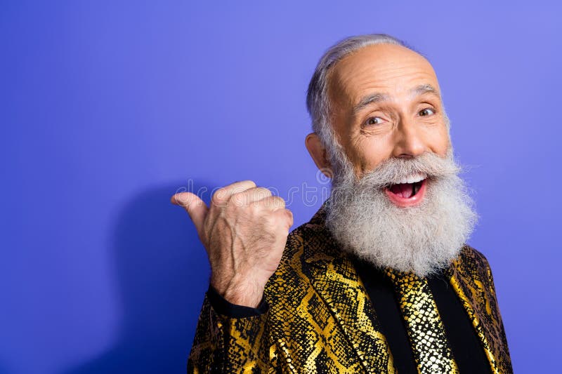 Homme âgé avec barbe élégante vêtu d'une tenue glamour sur fond violet exprimant une attitude joyeuse photos libres de droits