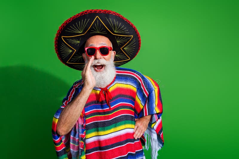 Homme âgé dans poncho mexicain coloré et sombrero faisant un geste enthousiaste sur un fond vert vibrant images stock