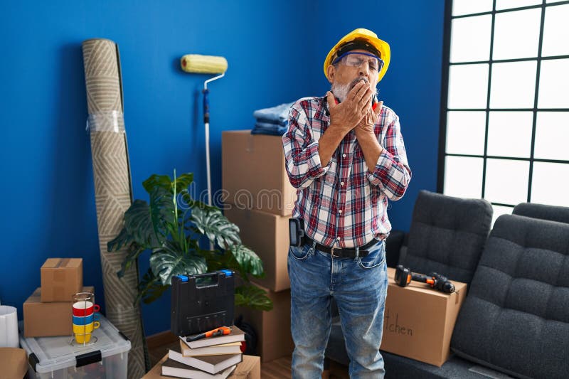 Homme âgé fatigué pris dans un bâton! lunettes de sécurité sport hardhat à nouveau domicile luttant somnolence passer sur la bouch images libres de droits