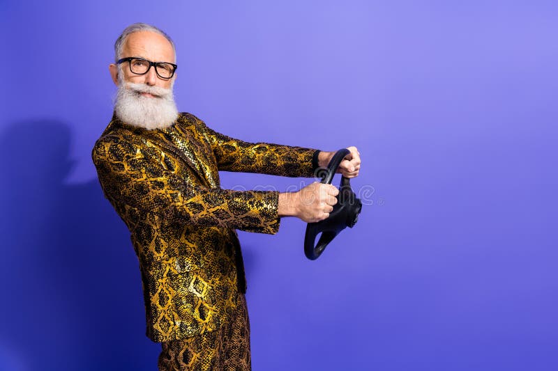 Homme âgé élégant en costume d'impression de reptile flamboyant posant avec confiance sur fond violet vibrant photos libres de droits