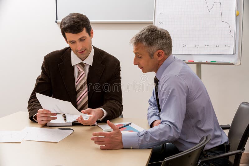 Hommes avec l'intérêt de discuter le plan d'action photo libre de droits Hommes avec l'intérêt de discuter le plan d'action photo libre de droits