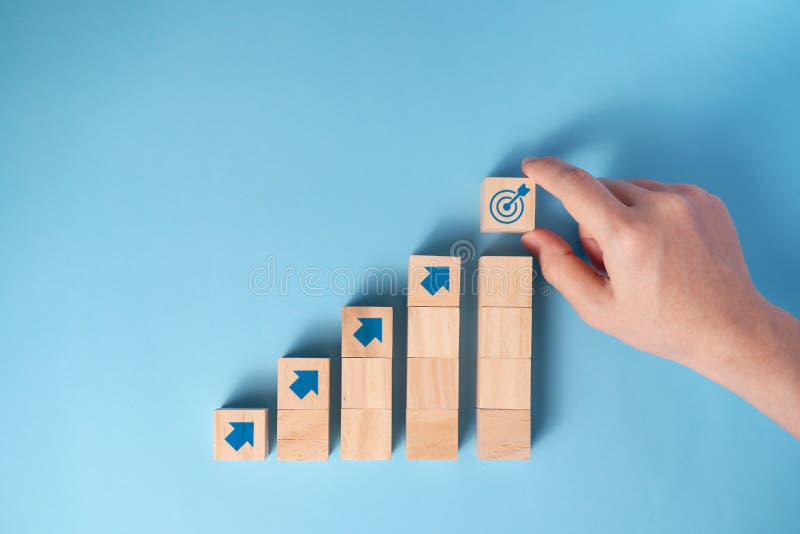 Businessman`s hand arranging wooden blocks staircase with arrow icon, Business planning concept. Businessman`s hand arranging wooden blocks staircase with arrow icon, Business planning concept