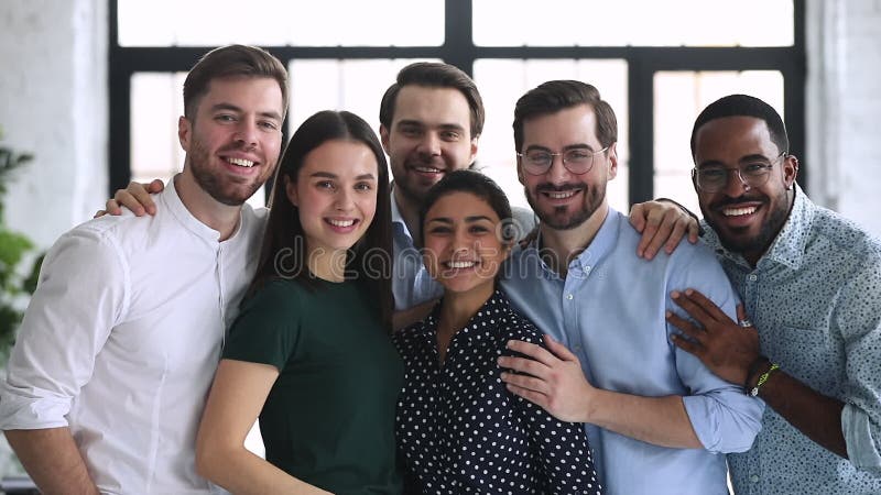 Hommes d'affaires différents professionnels heureux d'équipe collant le support au bureau clips vidéos