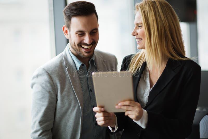 Hommes d'affaires discutant tout en ? l'aide du comprim? num?rique dans le bureau photo stock Hommes d'affaires discutant tout en ? l'aide du comprim? num?rique dans le bureau photo stock