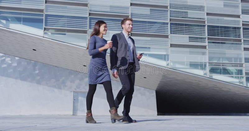 Hommes d'affaires en marche et la femme d'affaires et l'homme d'affaires dehors banque de vidéos