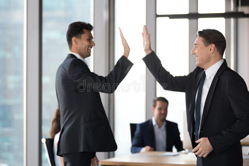 Hommes d'affaires exécutifs enthousiastes heureux de collègues donnant haut cinq dans le bureau image stock Hommes d'affaires exécutifs enthousiastes heureux de collègues donnant haut cinq dans le bureau image stock