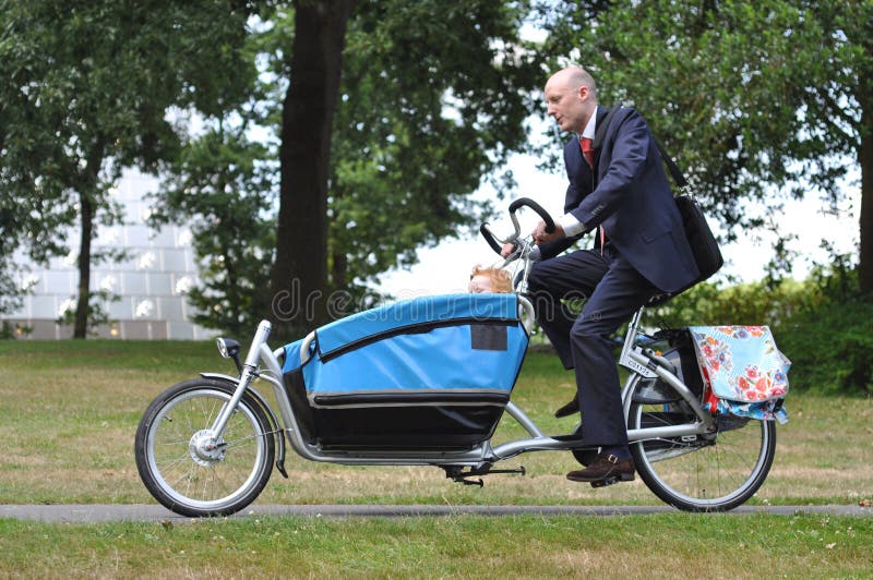 Business men hurrying on the carriere bike to the child creche. Business men hurrying on the carriere bike to the child creche