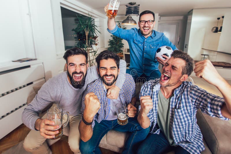 Hommes observant le sport sur des cris de TV ensemble à la maison gais images libres de droits Hommes observant le sport sur des cris de TV ensemble à la maison gais images libres de droits