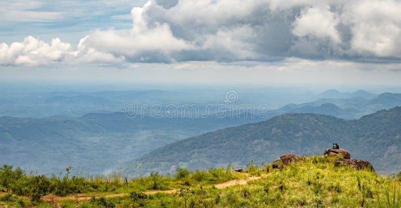 Hommes s'asseyant sur la roche pour la vue de paysage image stock Hommes s'asseyant sur la roche pour la vue de paysage image stock