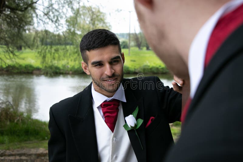 Homoseksualna para fornal poza dla fotografii jeziorem na ich dniu ślubu obrazy stock Homoseksualna para fornal poza dla fotografii jeziorem na ich dniu ślubu obrazy stock