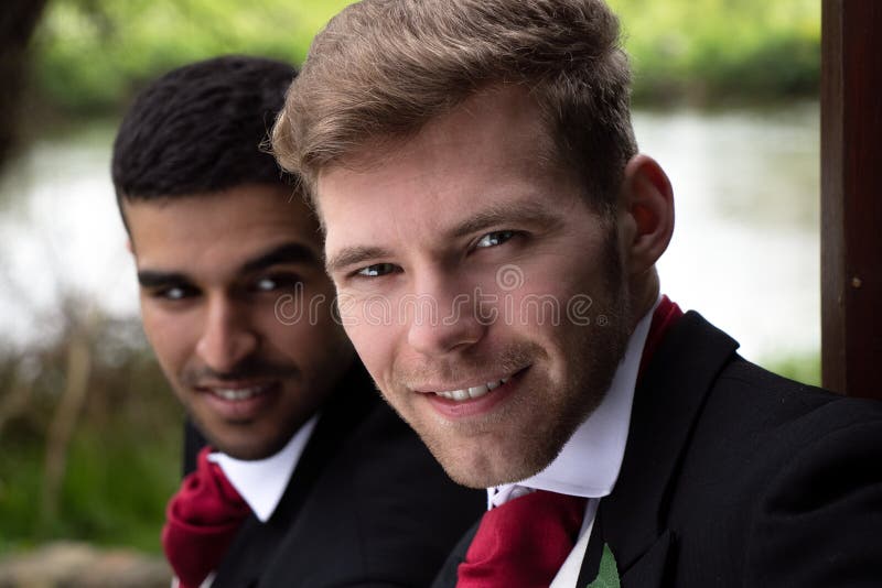 Homoseksualna para fornal poza dla fotografii jeziorem na ich dniu ślubu obraz stock Homoseksualna para fornal poza dla fotografii jeziorem na ich dniu ślubu obraz stock