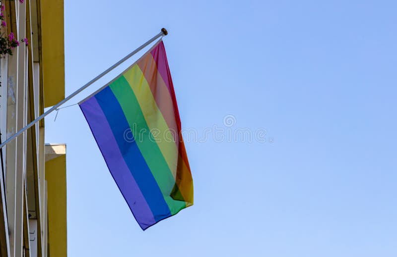 Homosexueller Stolz fahnenschwenkend gegen klaren blauen Himmel stockfoto Homosexueller Stolz fahnenschwenkend gegen klaren blauen Himmel stockfoto