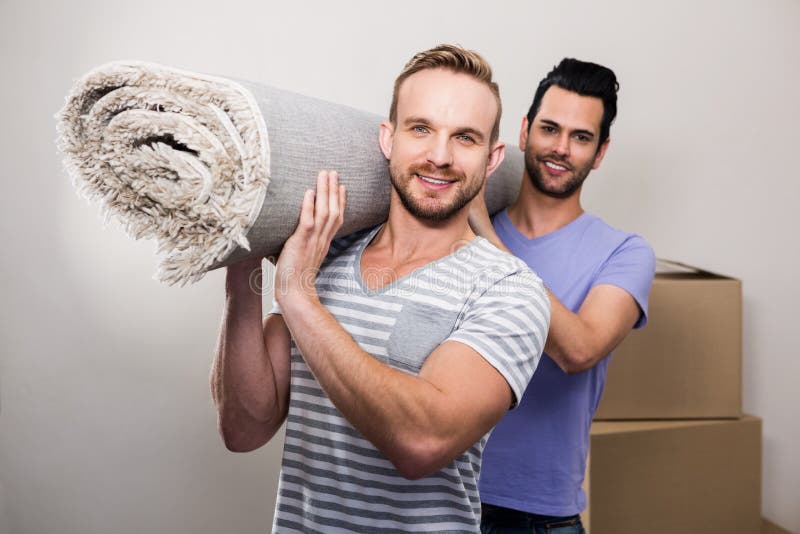 Homosexuelles Paartragen gerollt herauf Teppich lizenzfreies stockbild Homosexuelles Paartragen gerollt herauf Teppich lizenzfreies stockbild
