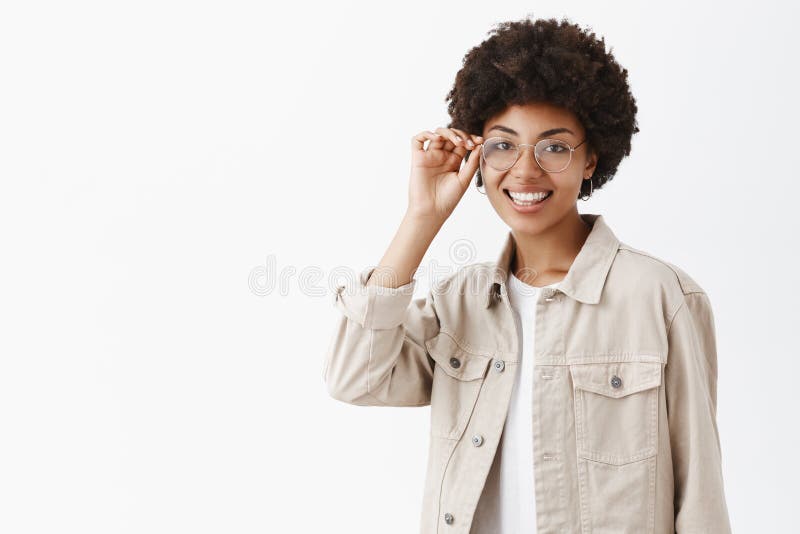 Hon vet allt om stil och mode Studioskott av den snygga lyckliga och kvinnliga afrikanska amerikanen med afro royaltyfri foto Hon vet allt om stil och mode Studioskott av den snygga lyckliga och kvinnliga afrikanska amerikanen med afro royaltyfri foto