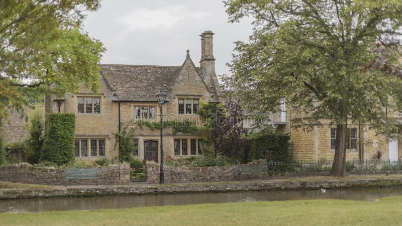 Honey coloured Cotswolds cottages on the river Windrush royalty free stock photo