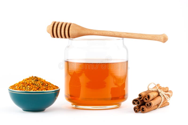 Honey in jar with dipper, cinnamon , pollen on isolated background