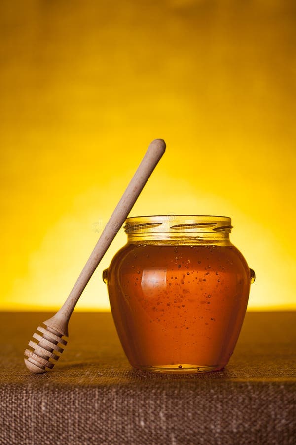 Honey jar with dipper on table