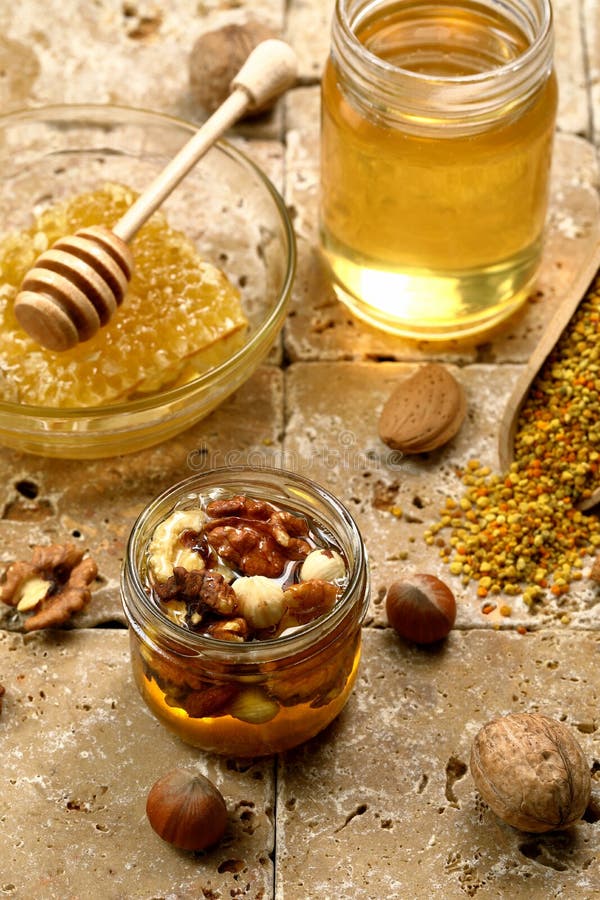 Honey In Glass Jar With Nuts On Rustic Wood Background Stock Photo