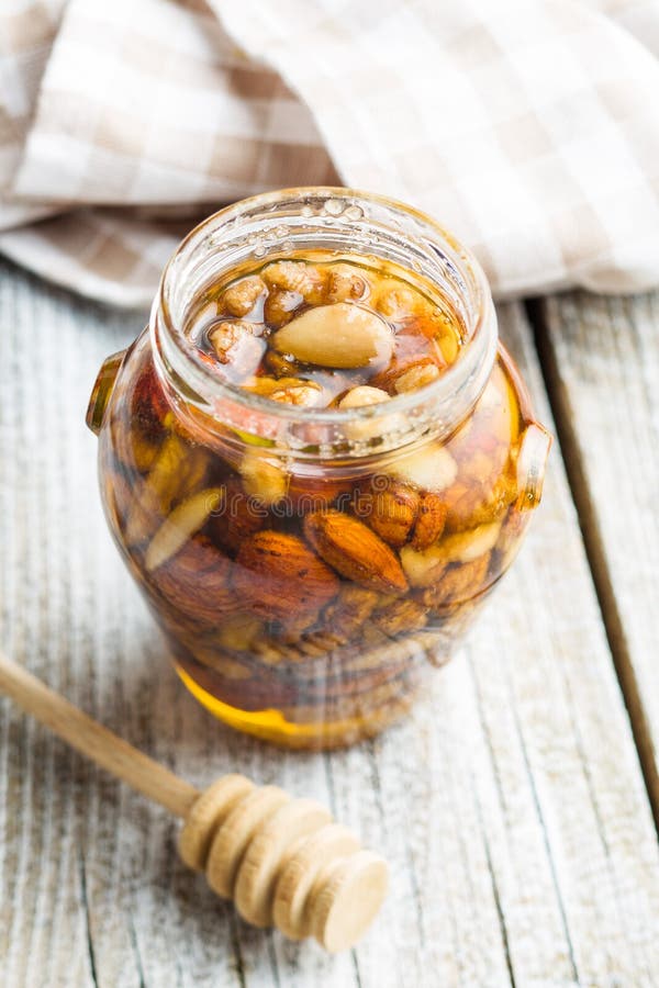 Jar of nuts in honey isolated on white background Stock Photo